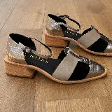 Zapato cerrado tipo sandalia de Vanitas, confeccionado en cuero vacuno. Presenta un diseño tricolor con paneles en negro, beige y detalles en cuero plateado con textura de reptil. Cuenta con punta fina, taco de madera de 4 cm y cierre con pulsera al tobillo.