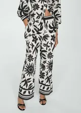Pantalon de corte wideleg con cintura elastizada, confeccionado en tejido fluido con estampado floral en contraste. Presenta bolsillos laterales y diseño largo.