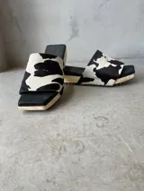 Zueco con capellada de cuero con estampado animal en blanco y negro, base de madera y suela de goma.