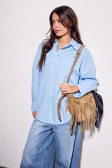 Camisa oversize de lino y viscosa color celeste, con cuello clásico, cierre frontal con botones y mangas largas.