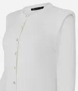 Cardigan de punto color blanco, de corte regular y ajuste al cuerpo. Presenta cuello redondo, mangas largas, cierre frontal con botones delicados y hombreras estructuradas que aportan volumen a la silueta.