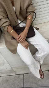 Brazalete rígido abierto de bronce con textura irregular.