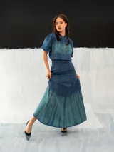 Falda larga azul con efecto degradado en verde, de corte a la cintura con dos bolsillos laterales y cierre invisible. Confeccionada en algodón tipo seda y teñida a mano.