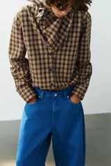 Jeans de tiro medio estilo balloon en color negro, con diseño de cinco bolsillos, trabillas para cinturón y cierre frontal con cremallera y botón metálico.