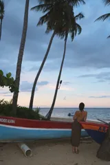 Vestido midi de tejido de punto con acabado brillante, diseño halter con espalda descubierta y detalle de piedras de resina en el cuello. Presenta un tajo lateral pronunciado.