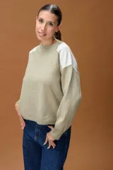 Sweater de punto color beige con cuello redondo y detalles de parches en cuero sintético blanco en los hombros. Presenta mangas largas con puños acanalados y un corte holgado.