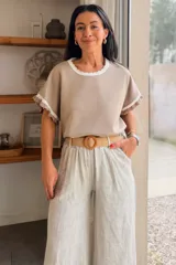 Remera negra de manga corta con detalles en contraste blanco en el cuello redondo y en los puños, con terminaciones onduladas.