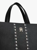 Cartera tipo satchel de Tommy Hilfiger en color negro, confeccionada en material texturizado. Presenta doble asa superior, correa ajustable extraíble y un diseño frontal con dos bandas verticales decorativas y el logo metálico TH en el centro.