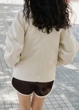 Short color marrón oscuro con cintura elástica, diseño corto y recto, y ribetes en contraste.