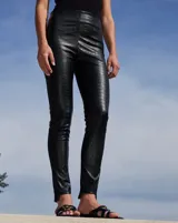 Pantalón de tiro alto confeccionado en ecocuero con textura efecto croco. Presenta un cierre metálico lateral y elástico interno en la cintura.