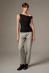 Blusa de poliéster negra, sin mangas, con cuello asimétrico, detalles bordados y sutiles lentejuelas.