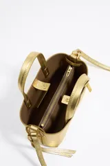 Bolso mini dorado de cuero con doble asa corta y correa fina ajustable.