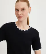 Top de manga corta ajustado al cuerpo, color marrón oscuro, con cuello redondo y bordes festoneados en color crema o beige claro.