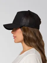 Gorro tipo trucker de color negro con malla trasera, visera curva y parche frontal con el logo de CAT en amarillo.