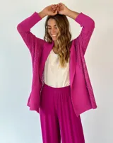 Saco tejido de punto abierto color fucsia, de manga larga y corte amplio, con cuello solapa.