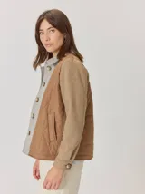 Campera de diseño híbrido con frente acolchado en color tostado, solapas y cuello en tejido de lana con patrón de cuadros tipo príncipe de gales, y mangas en paño de lana color azul marino. Cuenta con cierre frontal de botones.