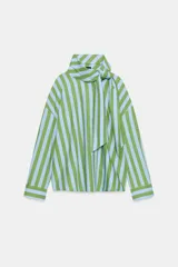 Camisa de manga larga con cuello subido y detalle de lazada frontal. Presenta un diseño de rayas verticales en tonos verde y celeste, con cierre frontal de botones y puños clásicos.