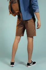 Bermuda de gabardina color tostado, de corte recto y largo por encima de la rodilla, con cierre y botón frontal.