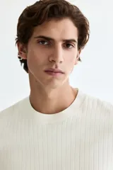 Remera blanca de punto acanalado fino, de corte ajustado, con cuello redondo y mangas cortas.