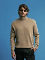 Polera de punto de manga larga en color azul marino, con cuello alto doblado y puños y ruedo acanalados.