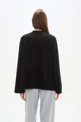 Sweater de viscosa color rojo, con cuello polera, corte holgado y pespuntes decorativos.