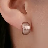 Aros tipo argolla pequeña de diseño ancho y superficie texturizada con acabado mate en tono dorado.