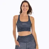 Top deportivo Merrell modelo Savannah Bra color gris oscuro con estampado sutil y logo de la marca en blanco. Cuenta con tirantes anchos y diseño sin mangas.