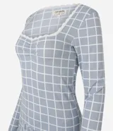 Pijama de dos piezas confeccionado en tejido rib con estampado de cuadros. La blusa es de manga larga, con escote cuadrado decorado con encaje y detalle fruncido en el busto. El pantalón presenta corte recto y cintura elástica.