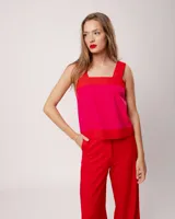 Pantalón negro de lino, tiro alto, corte palazo, con elástico en la pretina trasera, cierre delantero y broche interno. Tiene bolsillos laterales, dobladillo invisible y tajos a los costados.