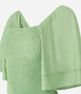 Blusa corta color verde claro con escote cuadrado y mangas cortas godê. Posee cuerpo en lastex, proporcionando un toque texturizado.