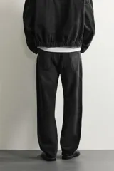 Pantalón de jean corte slim fit con efecto lavado, tiro medio, cinco bolsillos y cierre frontal con cremallera y botón.