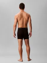 Pack de tres bóxers Calvin Klein de corte brief, color negro, con cintura elástica distintiva de la marca en negro y letras verdes. Confeccionados en algodón elástico para un ajuste cómodo.