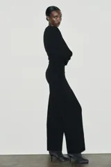 Pantalón de tiro alto con corte ancho y recto, confeccionado en tejido de punto elástico y flexible con cintura elástica.