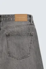 Jeans regular fit de denim de algodón en color gris con efecto lavado, tiro medio, diseño de cinco bolsillos y cierre frontal con botones.