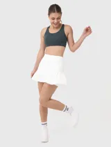 Falda deportiva blanca con short integrado, cintura alta y volados en el ruedo.