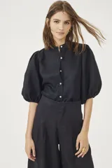 Pantalón culotte negro de lino orgánico, con cintura alta, diseño plisado y bolsillos laterales.