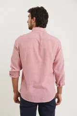 Camisa de manga larga confeccionada en una mezcla de algodón y lino, con cuello abotonado, cierre frontal de botones y un bolsillo en el pecho.