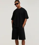 Bermuda masculina de algodón y poliéster, color gris oscuro, con cintura elástica y cordón ajustable. Presenta bolsillos funcionales.