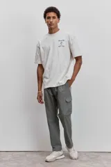 Remera de corte oversize color beige, con cuello redondo y estampa pequeña en el pecho.