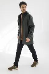 Campera impermeable verde con capucha, cierre frontal con botones a presión y bolsillos laterales con solapa.