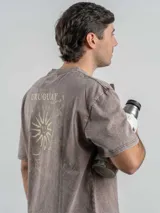 Remera de corte oversize color marrón con efecto lavado, cuello redondo y estampa frontal con la frase 'URUGUAY noma!'.
