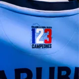 Camiseta de fútbol Umbro del Club Nacional de Football, edición especial celeste 2026. Diseño en color celeste con detalles en azul marino y blanco, con tejido jacquard inspirado en los 19 departamentos de Uruguay. Incluye el escudo del club, logo de Umbro, sponsors y emblemas oficiales en el frente.