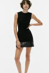 Vestido mini negro sin mangas, de cuello redondo, con detalle de tejido efecto piel combinado a tono en el bajo. Cuenta con forro interior y cierre en la espalda con cremallera oculta.