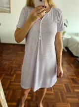 Camisón de manga corta, color lila claro, con cuello redondo y abertura frontal con botones. Tejido acanalado con estampado de pequeñas flores en tonos rosados y naranjas.