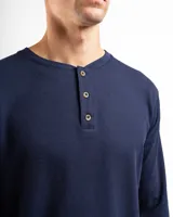 Remera tipo henley de manga larga confeccionada en tejido de algodón con textura mini piqué. Presenta un cierre frontal con tres botones y puños ajustados en las mangas.