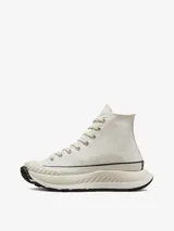 Championes Converse modelo Chuck 70 AT-CX de caña alta, con diseño de plataforma voluminosa y suela dentada. Presentan una capellada de lona en tono hueso, con el parche clásico de la marca en el lateral y puntera reforzada con textura acanalada.