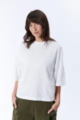 Remera blanca de corte holgado, con cuello alto y mangas 3/4.