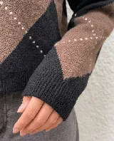 Sweater de punto con diseño de rombos en tonos marrones y beige, cuello redondo y mangas largas con puños acanalados.
