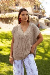 Chaleco de punto color beige, con escote en V y diseño holgado sin mangas.