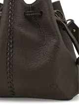 Cartera tipo morral de cuero graneado color marrón, con diseño tipo saco fruncido mediante tiras ajustables y costura central decorativa. Cuenta con correa regulable para llevar cruzada o al hombro.